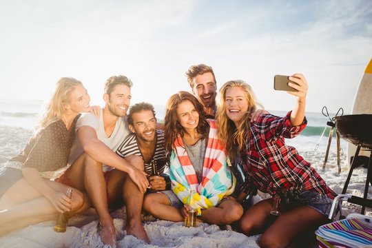 Happy friends taking selfie with smartphone