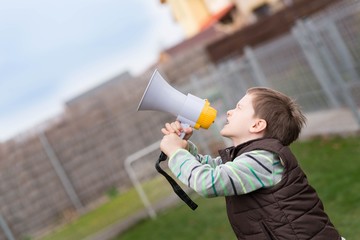Little boy screaming through a megaphone