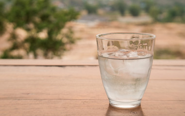 Glass Water on wooden floor,Blur background.