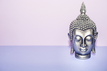 Buddha silver head portrait isolated on pink and violet background 