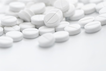 Pile of white pills in closeup on white background