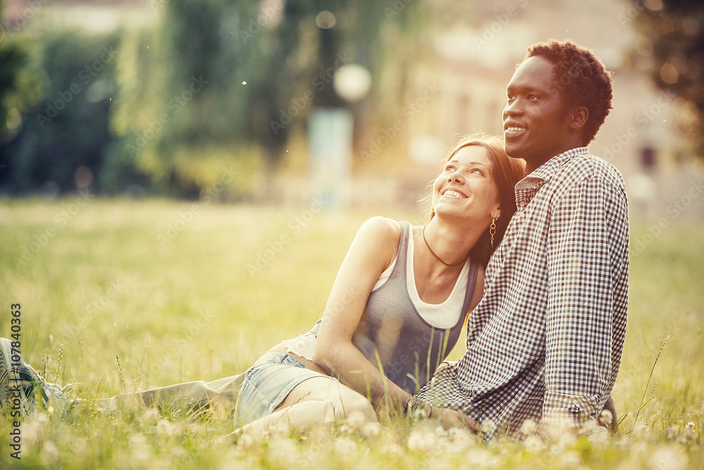 Wall mural young multi-ethnic couple having fun together at the park