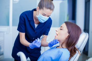 Beautiful woman patient having dental treatment at dentist's office. Woman visiting her dentist