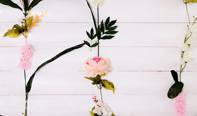 Artificial flowers on wood background