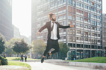 Fototapeta na wymiar Young handsome contemporary business man jumping outdoor in city back light - success, positive, winner concept
