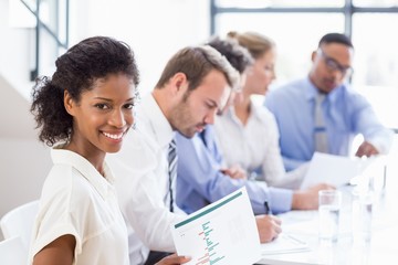 Portrait of businesswoman holding a report at meeting