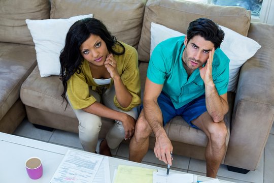 Portrait Of Worried Young Couple With Bills