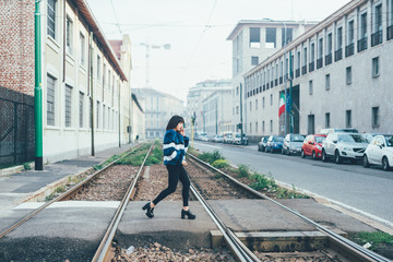 Young beautiful eastern woman walking outdoor in the city, cross