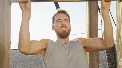 Crossfit fitness man exercising chin-ups workout. Young male adult trainer athlete portrait closeup with hands holding on monkey bars at outdoor gym doing a chin-up strength training muscle exercise. - Powered by Adobe