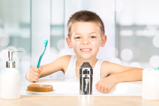 smiling child brush teeth in the bathroom