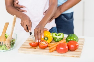 Obraz na płótnie Canvas Woman cutting vegetables on chopping board