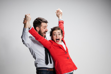 The business man and woman laughing on a gray background
