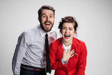 The business man and woman laughing on a gray background