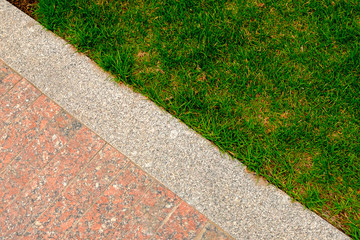 Old granite pavement and grass in garden decorative texture, line dividing nature and civilisation, concept