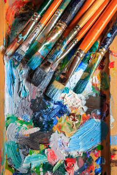 Colourful oil paint, different types of brushes and palette