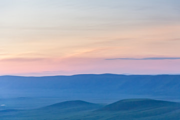 Fototapeta premium Panoramic view of huge Ngorongoro caldera (extinct volcano crater) against evening glow background at dusk. Great Rift Valley, Tanzania, East Africa.