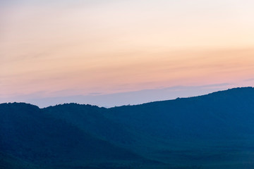 Panoramic view of huge Ngorongoro caldera (extinct volcano crater) against evening glow background at dusk. Great Rift Valley, Tanzania, East Africa.