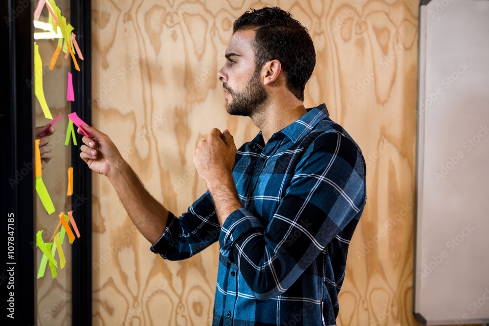 Aufkleber man looking at sticky notes on window