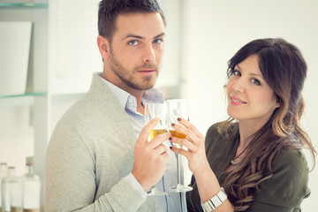 young casual couple cheers with champagne in the kitchen