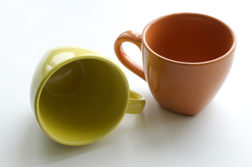 brightly yellow and orange ceramic cups on a light background
