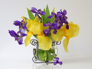 Bouquet of irises flowers in a vase. Floral home decoration with yellow and purple irises flowers in a vase.