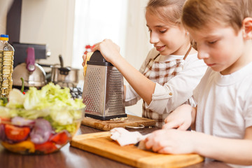 Small boy with his sister preparing food together