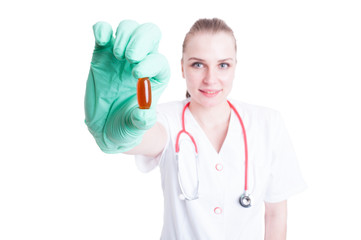 Close-up of smiling female doctor hand holding a pill