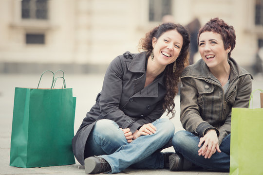smiling happy women shop together in cityscape
