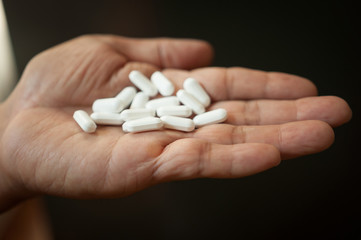 Medicine pills or capsules in hand