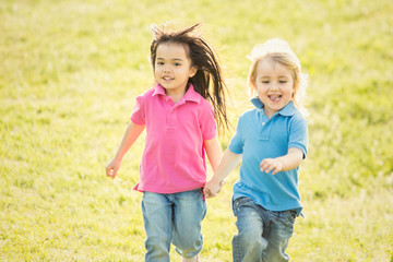 couple of interracial children play together in a garden