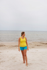 Tired woman standing on the beach