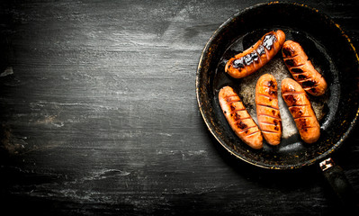 Grilled sausage with smoke in the pan.