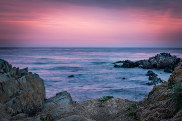 Colorful sunrise skyline viewed from the beach rocks