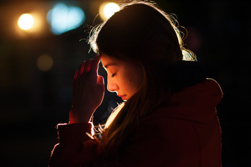 Closeup portrait of a young  woman praying © timonko