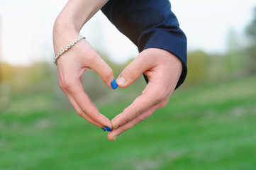 Close up of woman and man hands showing heart shape