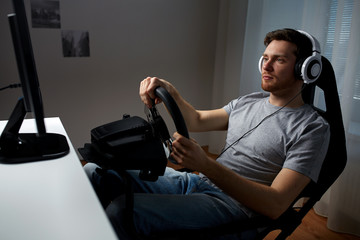 man playing car racing video game at home