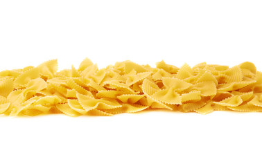 Line made of dry farfalle pasta over isolated white background