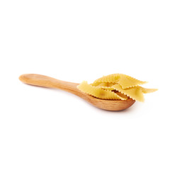 Naklejka premium Wooden spoon filled with dry farfalle pasta over isolated white background