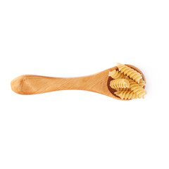 Wooden spoon filled with dry rotini pasta over isolated white background