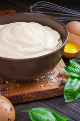 Bowl with homemade mayonnaise on a dark background
