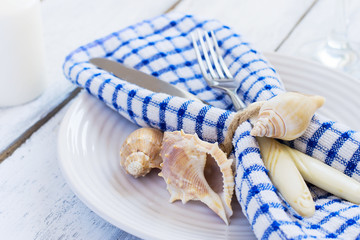 Summer table setting in marine style, decorated with shells