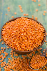 Red lentils in bowl on a blue wooden table