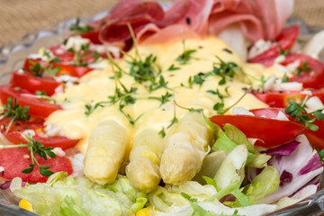 Aerial view white asparagus tomatoes lettuce salad on burlap background