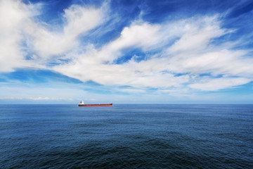 Fototapeta na wymiar Cargo ship under blue sky in the sea.