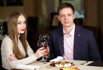 Couple toasting wineglasses in a luxury restaurant.