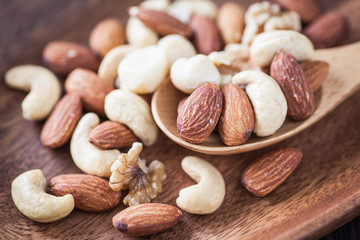 Assorted mixed nuts , Almond , Cashews nuts , macadamia , walnut in wood spoon