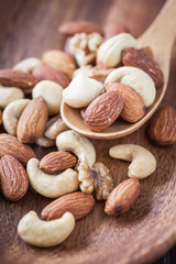 Assorted mixed nuts , Almond , Cashews nuts , macadamia , walnut in wood spoon