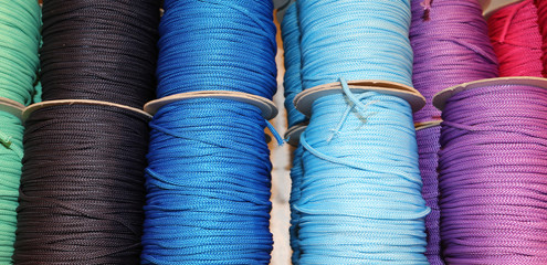 colored spools of thread and balls of wool for sale