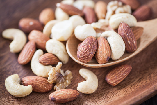 Assorted mixed nuts , Almond , Cashews nuts , macadamia , walnut in wood spoon