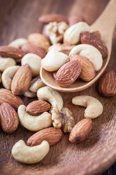 Assorted mixed nuts , Almond , Cashews nuts , macadamia , walnut in wood spoon